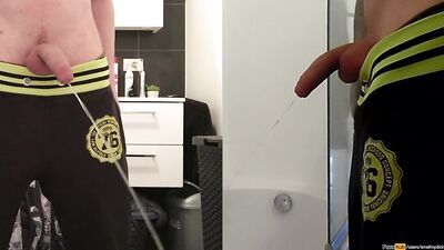 teen boy is urinating in the bathroom