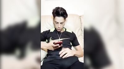 Sexy guy pleasures himself while playing with his cellphone and cock