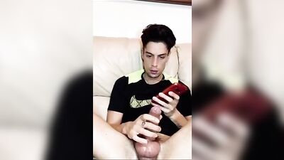Sexy guy pleasures himself while playing with his cellphone and cock