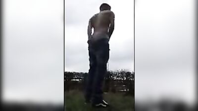 Gay amateur twink college jock showers on campus lawn, strokes his cock then shoots load in the open air