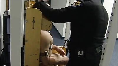 Leather-clad cop takes down a restrained inmate in a rough bondage scene