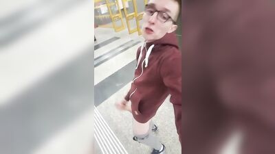 Handsome nerdy guy pleasures himself on a crowded street
