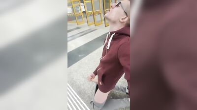 Handsome nerdy guy pleasures himself on a crowded street