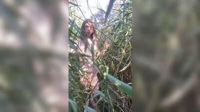 Skinny naked twink in the reeds showing his cock