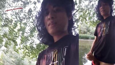 Jon Arteen walks in a gay cruising park, wanks, cums outdoors in front of water. Horny twink public