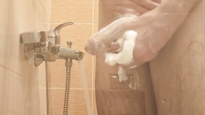 A young guy washes in the shower and plays with his dick