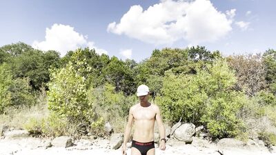 Sweaty runner does exercises outside