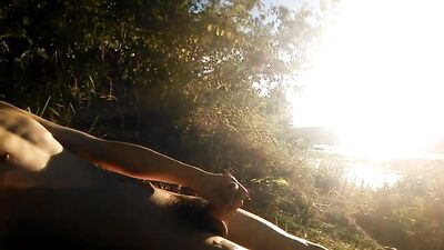 Natural teen boy lays nude by the river, wanks his hairy cock, squirts cum and relaxes during summer