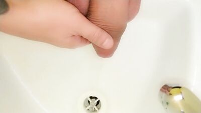 Peeing to the sink with uncut cock